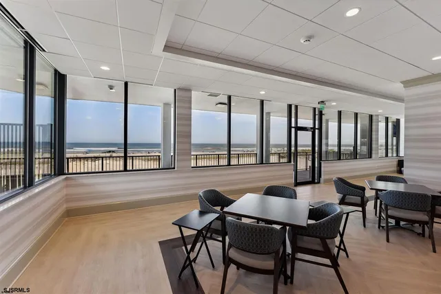 a dining room with furniture and large windows