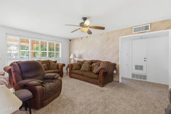 a living room with furniture ceiling fan and a window