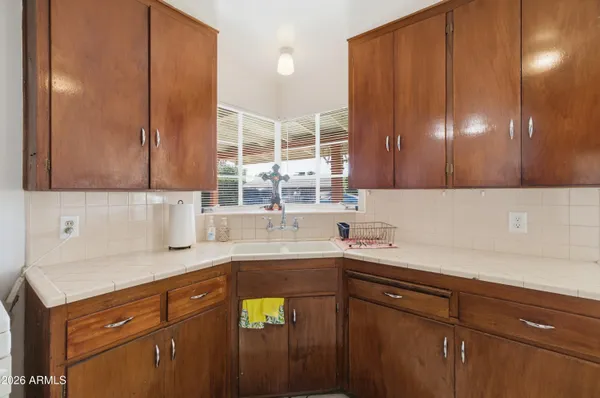 a kitchen with a refrigerator a stove top oven a sink and a window