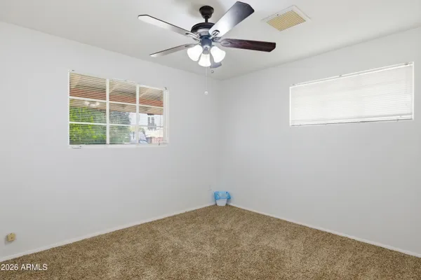 an empty room with closet and a chandelier fan