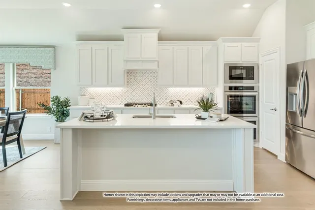 a kitchen with stainless steel appliances granite countertop a sink a stove and a refrigerator