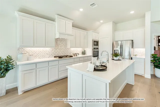 a kitchen with stainless steel appliances granite countertop a stove a sink and white cabinets