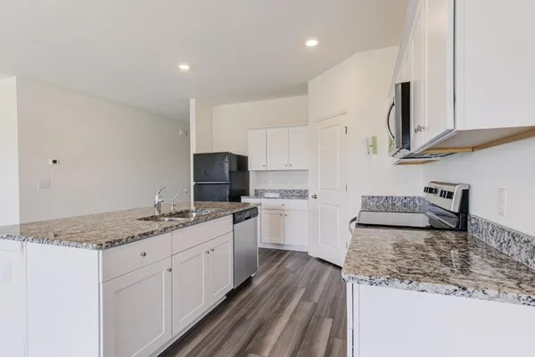 a kitchen with stainless steel appliances a stove a sink and a refrigerator