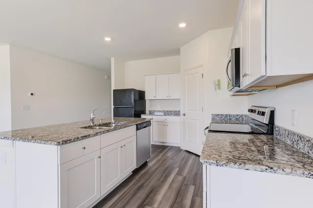 a kitchen with stainless steel appliances a stove a sink and a refrigerator