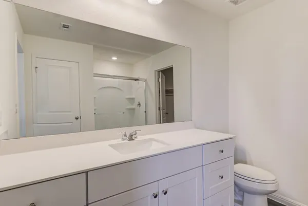 a bathroom with a sink a toilet and mirror