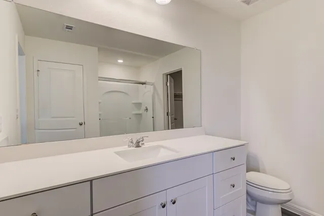 a bathroom with a sink a toilet and mirror
