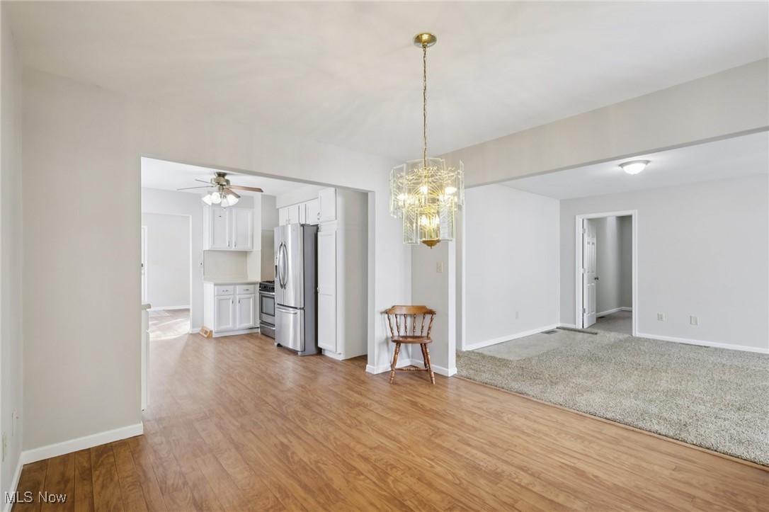 611 Wilson Street Struthers, OH 44471 - Photo 10 of 44 Unfurnished dining area with a chandelier, light wood finished floors, and a ceiling fan