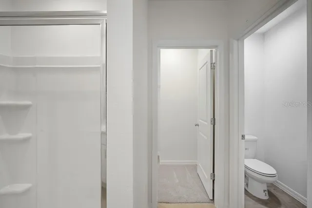 a bathroom with a granite countertop toilet and a shower