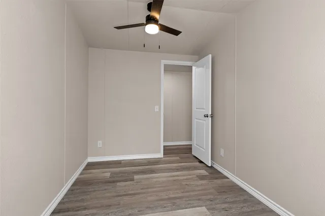 a view of an empty room and chandelier fan