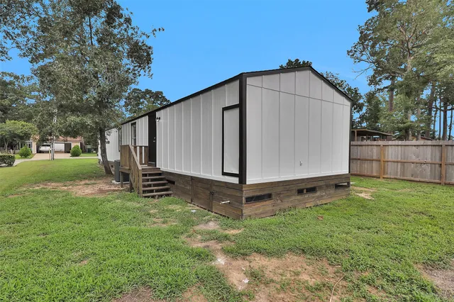 a view of a backyard with a small cabin and wooden fence