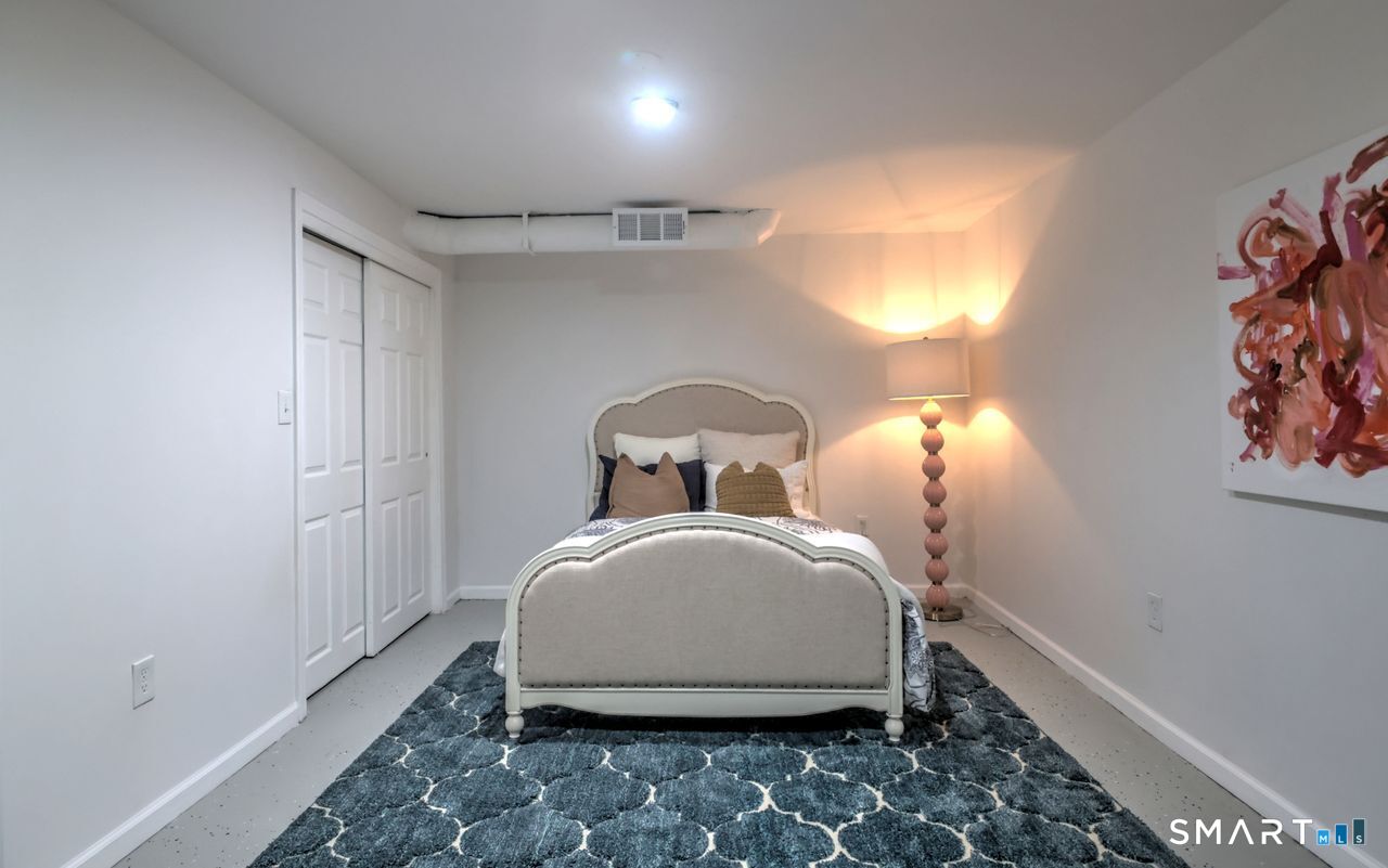 9 Canterbury Road, Unit 9 Hamden, CT 06514 - Photo 26 of 29 a large bed sitting in a bedroom next to a window