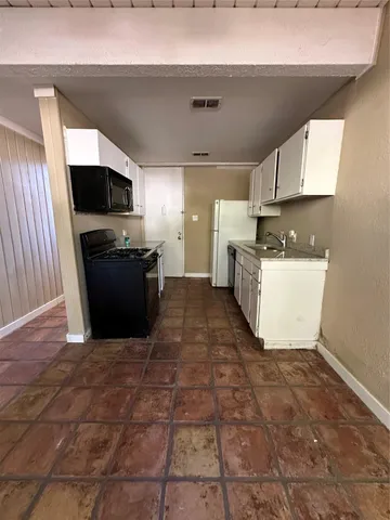 a view of a kitchen with cabinets and wooden floor