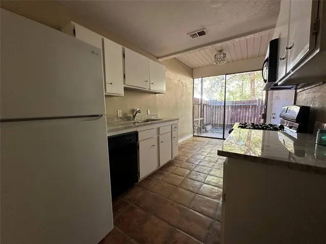 a kitchen with stainless steel appliances granite countertop a sink a stove and a refrigerator