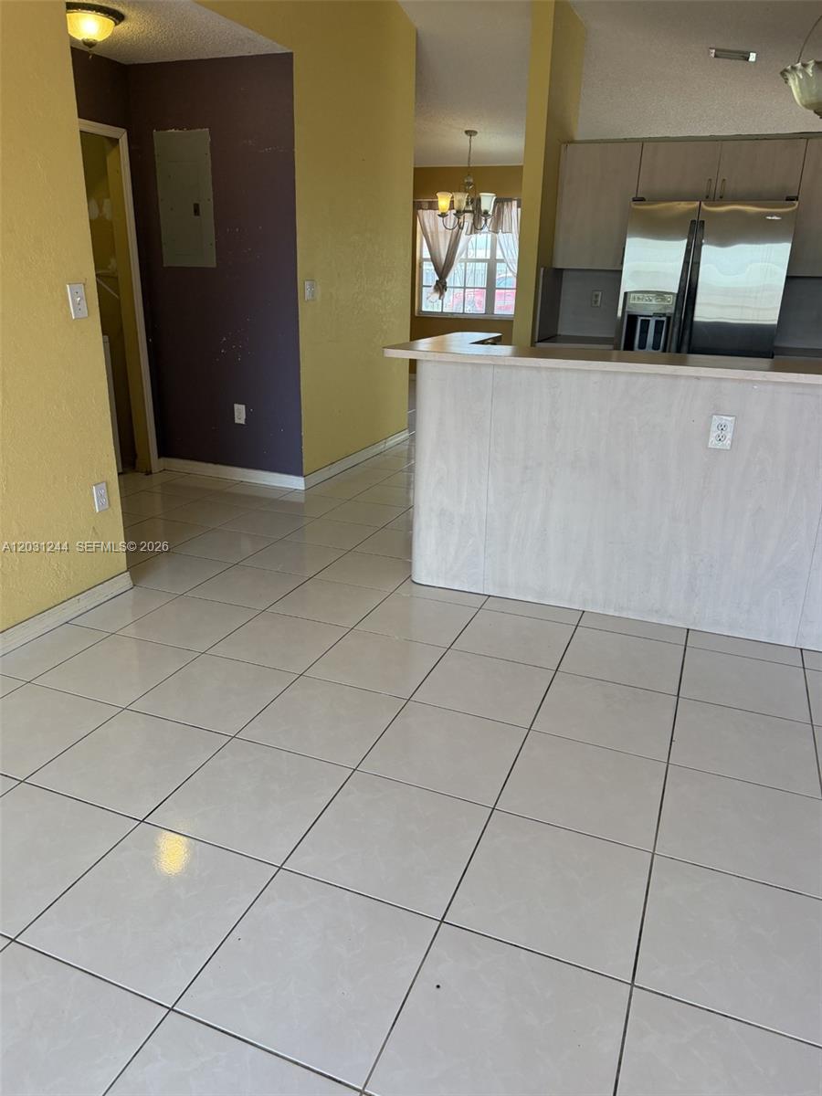 13752 Southwest 156th Street Miami, FL 33177 - Photo 4 of 14 a living room with a baby crib and a table