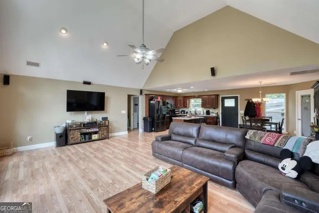 a living room with furniture a flat screen tv and a large window