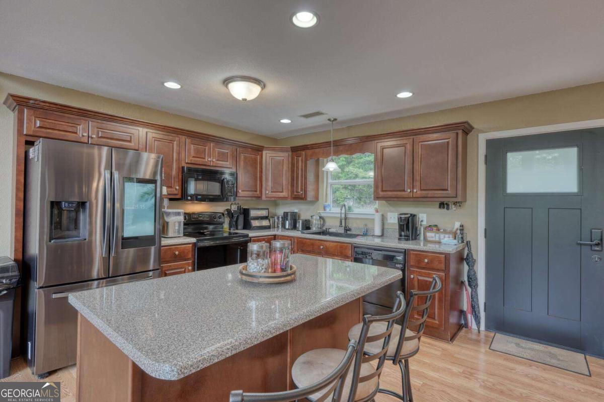 4165 Mobile Road, Unit 4 McCaysville, GA 30555 - Photo 17 of 52 a kitchen with a refrigerator a stove a sink a dining table and chairs