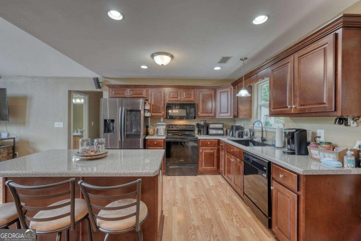 4165 Mobile Road, Unit 4 McCaysville, GA 30555 - Photo 18 of 52 a kitchen with stainless steel appliances granite countertop a stove top oven a sink dishwasher a dining table and chairs with wooden floor