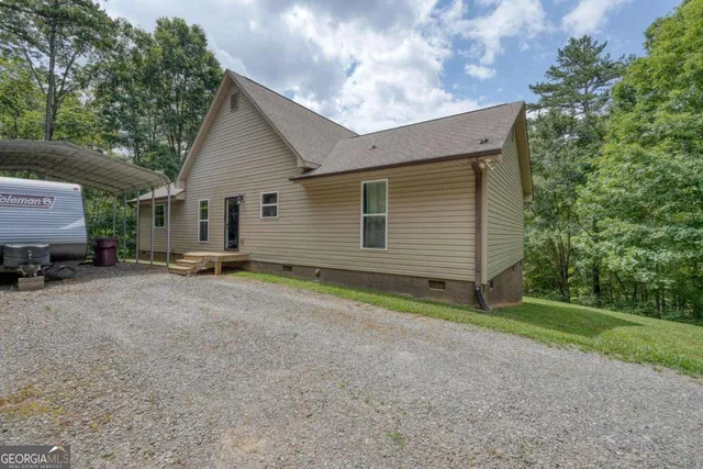 a view of a house with a yard and large tree