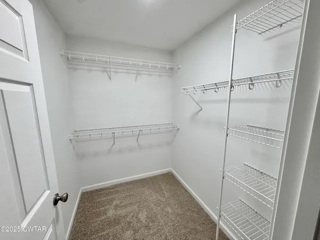 an empty room with windows and ceiling fan