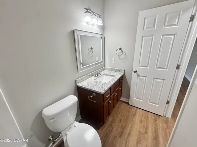 an empty room with a chandelier fan and windows