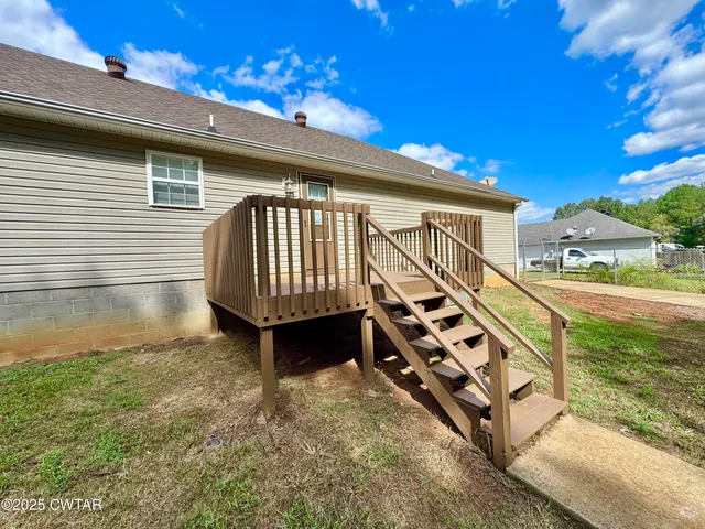 a view of a outdoor space with deck and tree