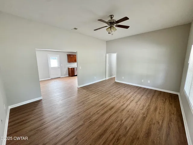 a kitchen with stainless steel appliances granite countertop wooden cabinets a stove top oven a sink and dishwasher with wooden floor