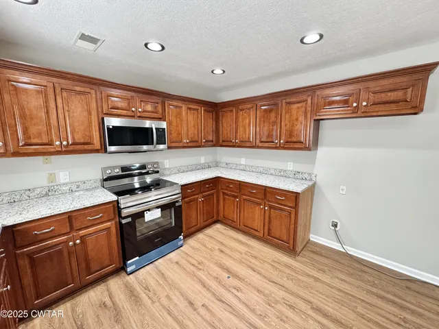 a bathroom with a granite countertop sink a mirror and shower