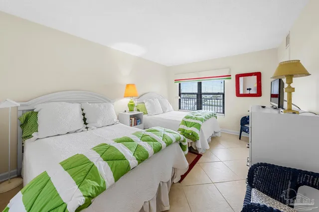 a bedroom with a bed mirror and window