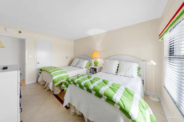 a bedroom with two beds and a large window