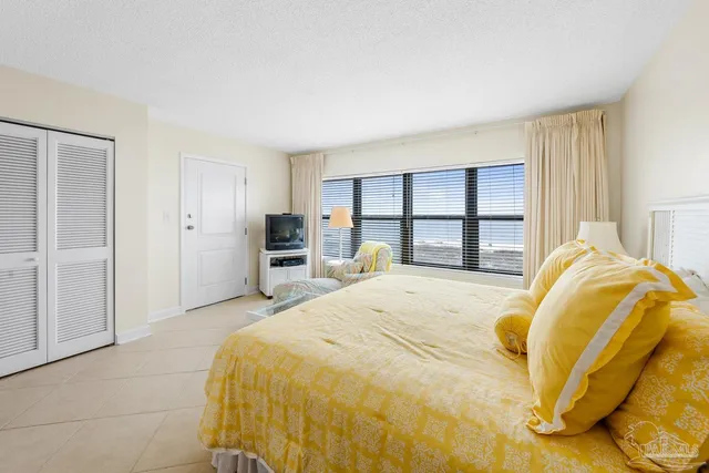 a bedroom with a bed and a large window