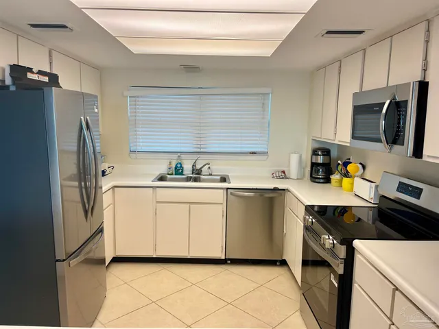 a kitchen with stainless steel appliances a refrigerator sink and microwave