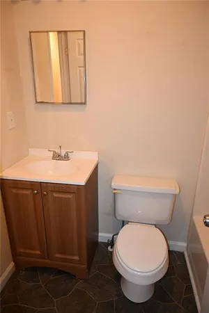 a bathroom with a toilet a sink and mirror