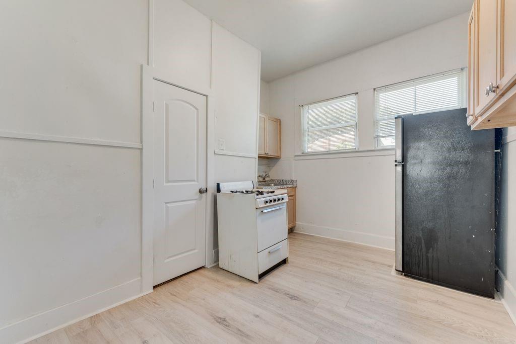 1615 Alston Avenue, Unit C Fort Worth, TX 76104 - Photo 4 of 10 a room with a refrigerator and a stove