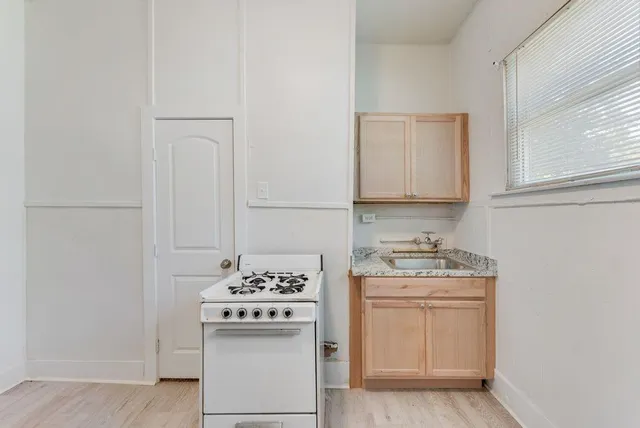 a kitchen with stainless steel appliances a white stove top oven and sink