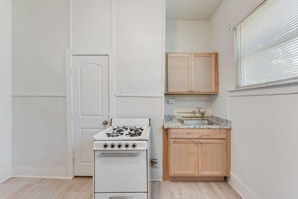 1615 Alston Avenue, Unit C Fort Worth, TX 76104 - Photo 5 of 10 a kitchen with stainless steel appliances a white stove top oven and sink