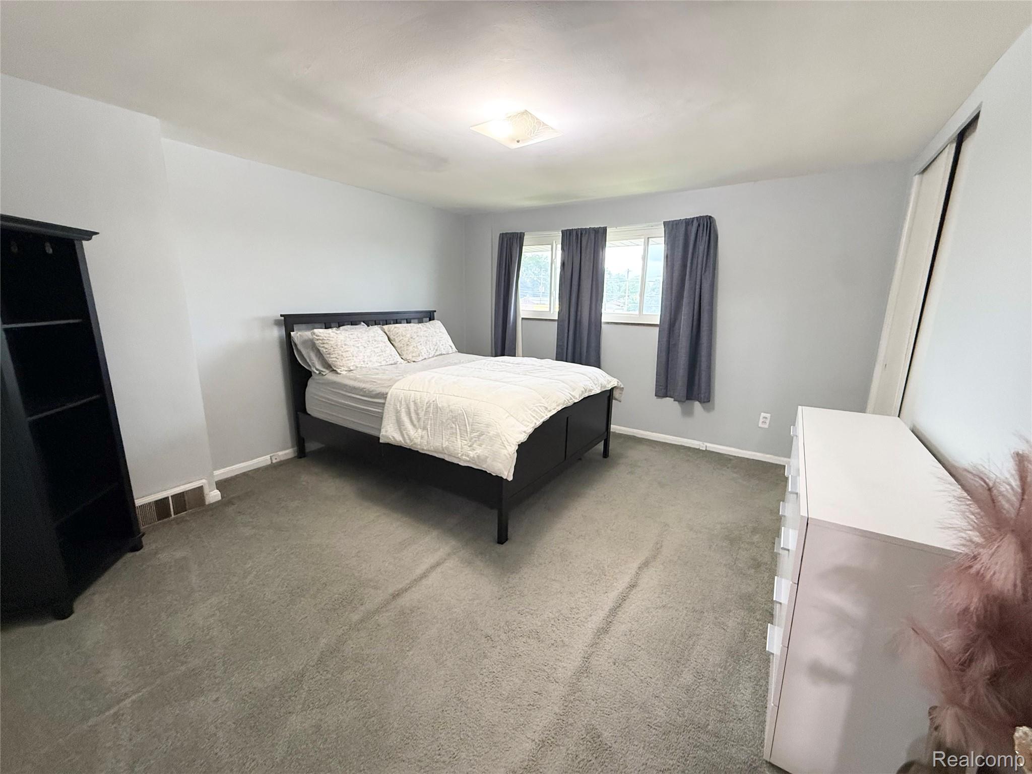 11012 Middlebelt Road Livonia, MI 48150 - Photo 8 of 14 Spacious interior room featuring light gray wall paint, gray carpet flooring, and multiple windows