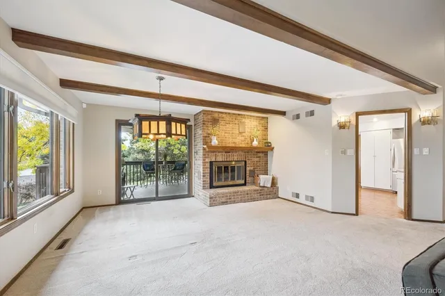 a view of an empty room with a fireplace and a window
