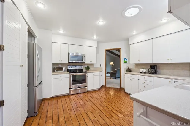 a kitchen with white cabinets and stainless steel appliances