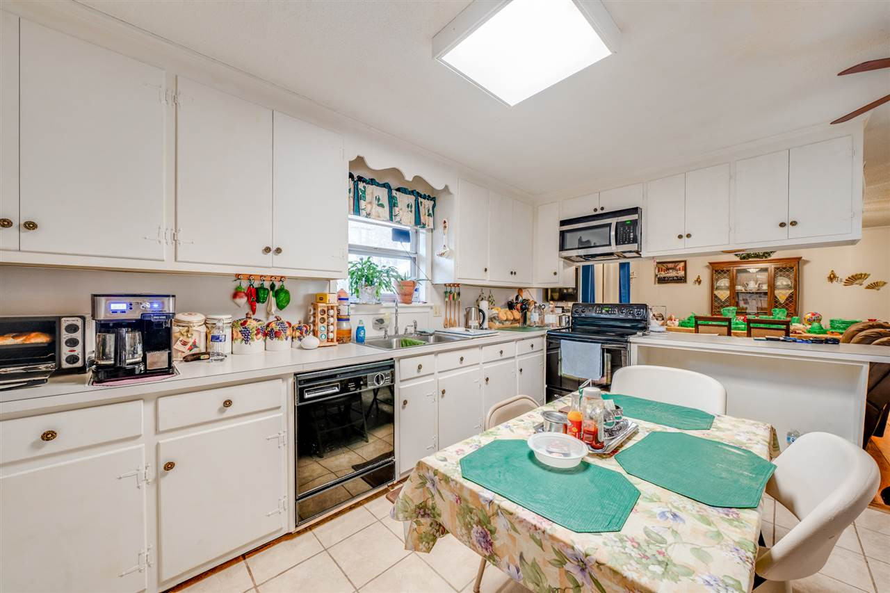 720 Bayard Road Durham, NC 27703 - Photo 5 of 28 a open kitchen with granite countertop white cabinets and white appliances