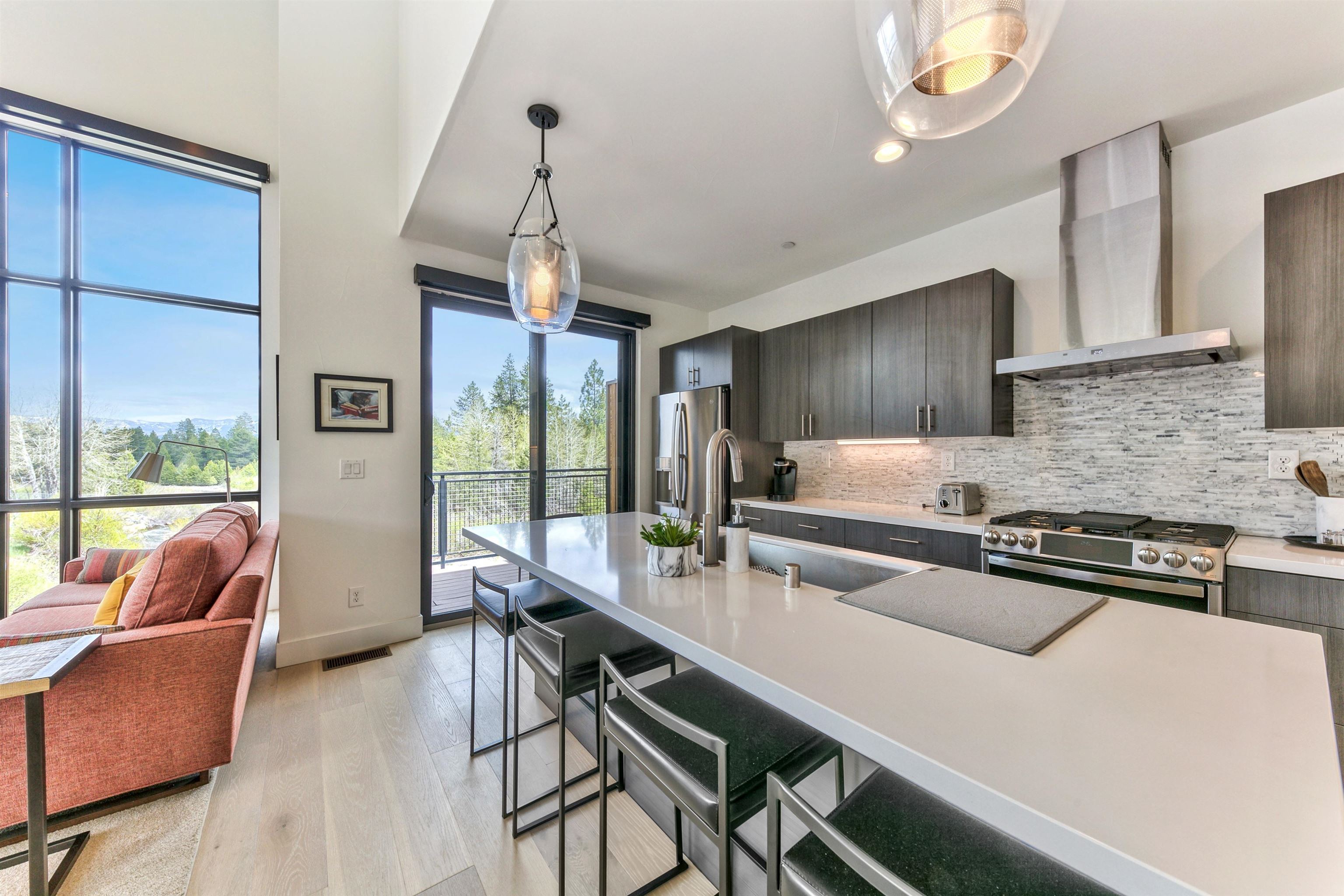 12869 Ice House Loop Truckee, CA 96161 - Photo 15 of 21 a kitchen with stainless steel appliances granite countertop a stove a refrigerator a sink a dining table and chairs with wooden floor