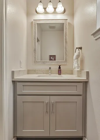 a bathroom with a sink vanity and a mirror