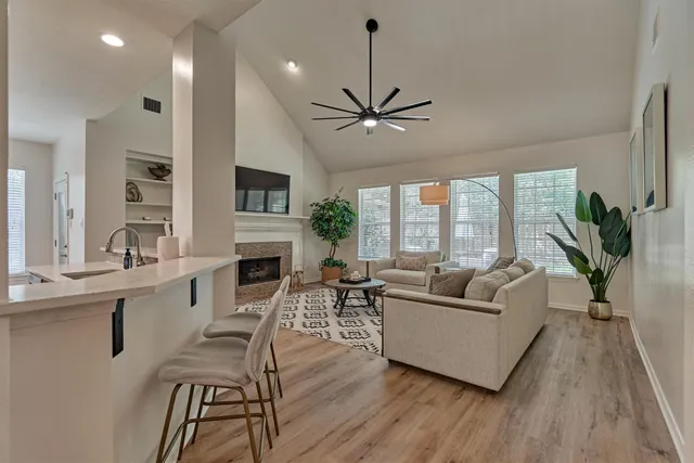 a living room with furniture a fireplace and a flat screen tv