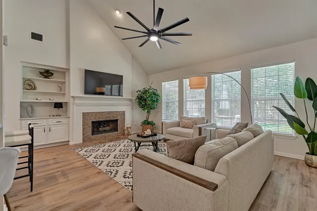 a living room with furniture fireplace and a large window