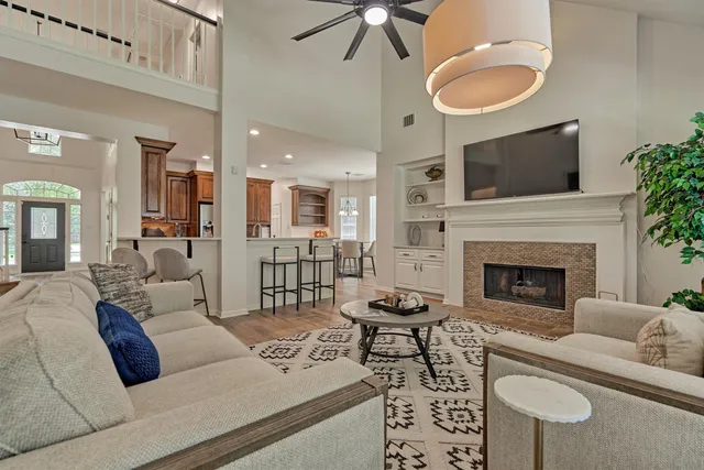 a living room with furniture a fireplace and a flat screen tv