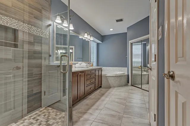 a bathroom with a double vanity sink toilet and shower