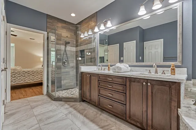a bathroom with a double vanity sink a large mirror and a shower