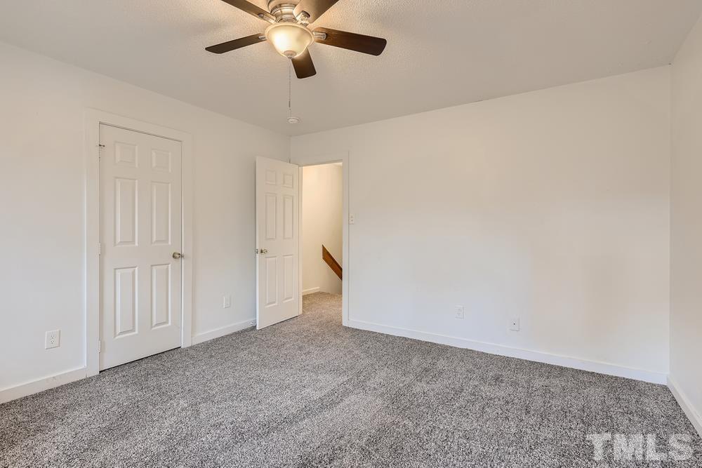 5604 Thea Lane, Unit B Raleigh, NC 27606 - Photo 19 of 27 an empty room with a ceiling fan and a window