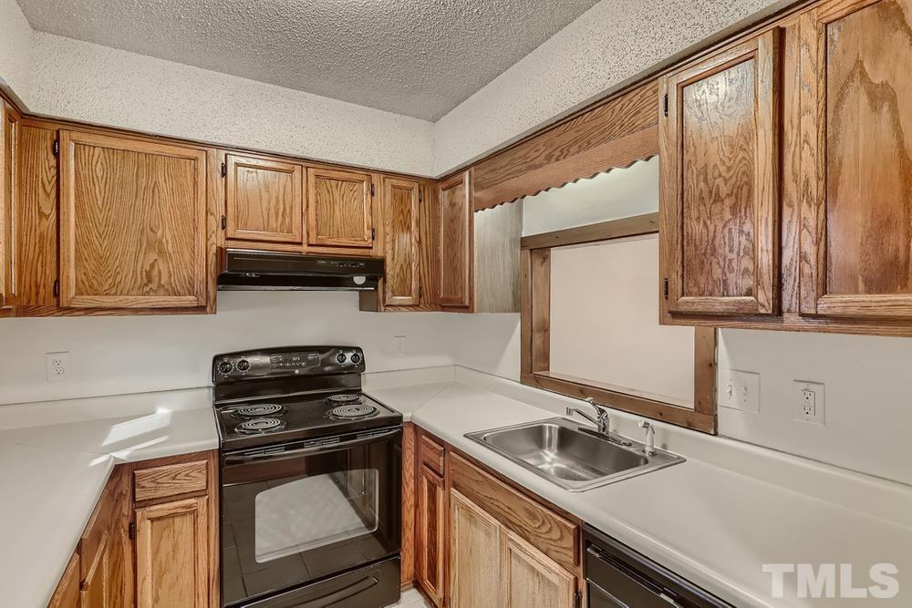 5604 Thea Lane, Unit B Raleigh, NC 27606 - Photo 10 of 27 a kitchen with granite countertop a sink a stove and cabinets