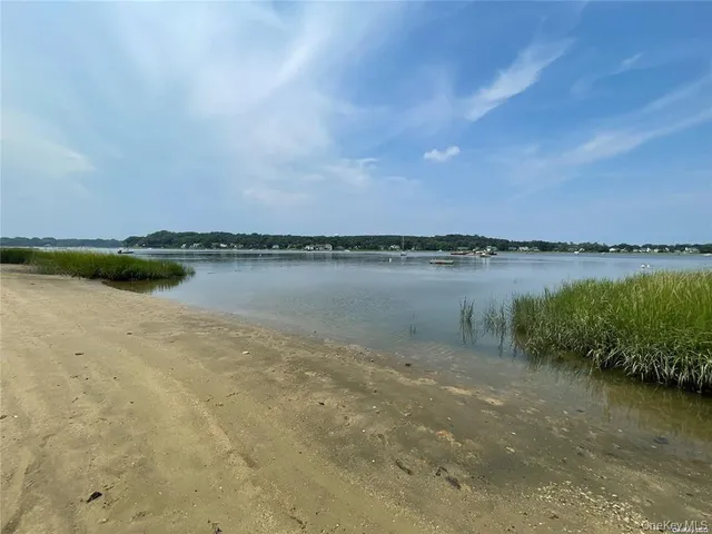an aerial view of a houses with a yard and lake view