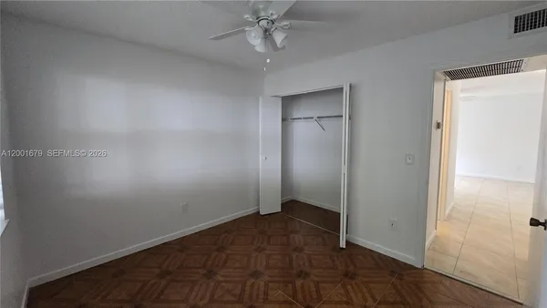 an empty room with closet and a hallway